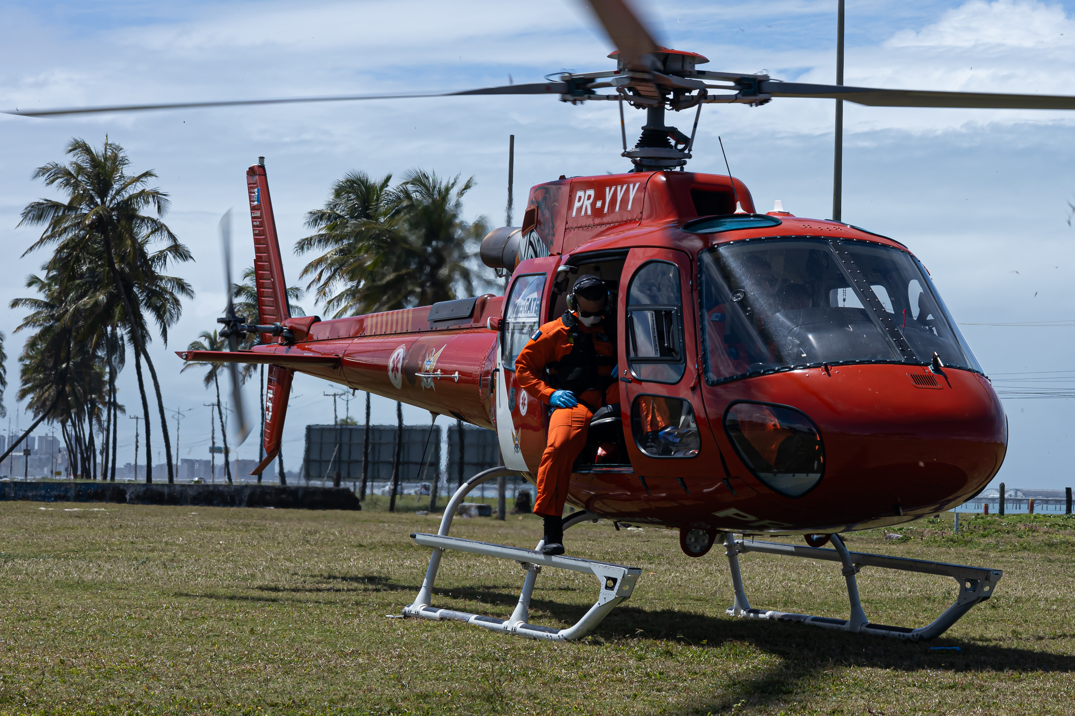 Profissional de resposta emergencial ao lado de helicóptero operacional
